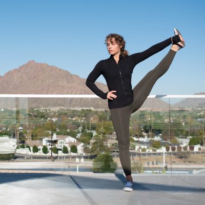 woman doing standing yoga pose on the rooftop with Camelback Mountain in background