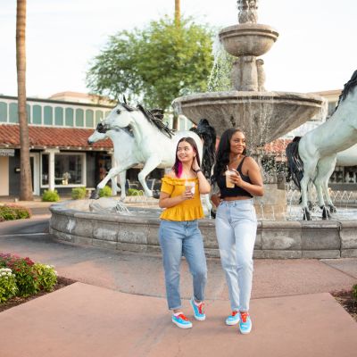 two women in matching sneakers in front of horse fountain in Old Town